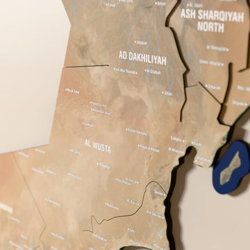 Close-up of the Satellite Oman wooden wall map with layered regions and printed names