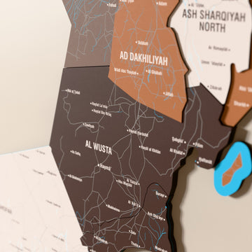 Close-up of the Soil Oman wooden wall map with layered regions and printed names
