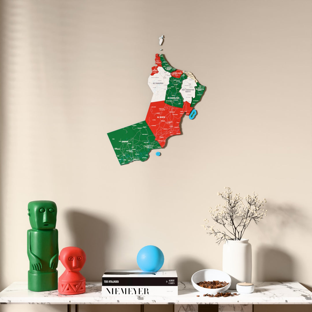 Flag colored Oman wooden wall map above a marble console, front view