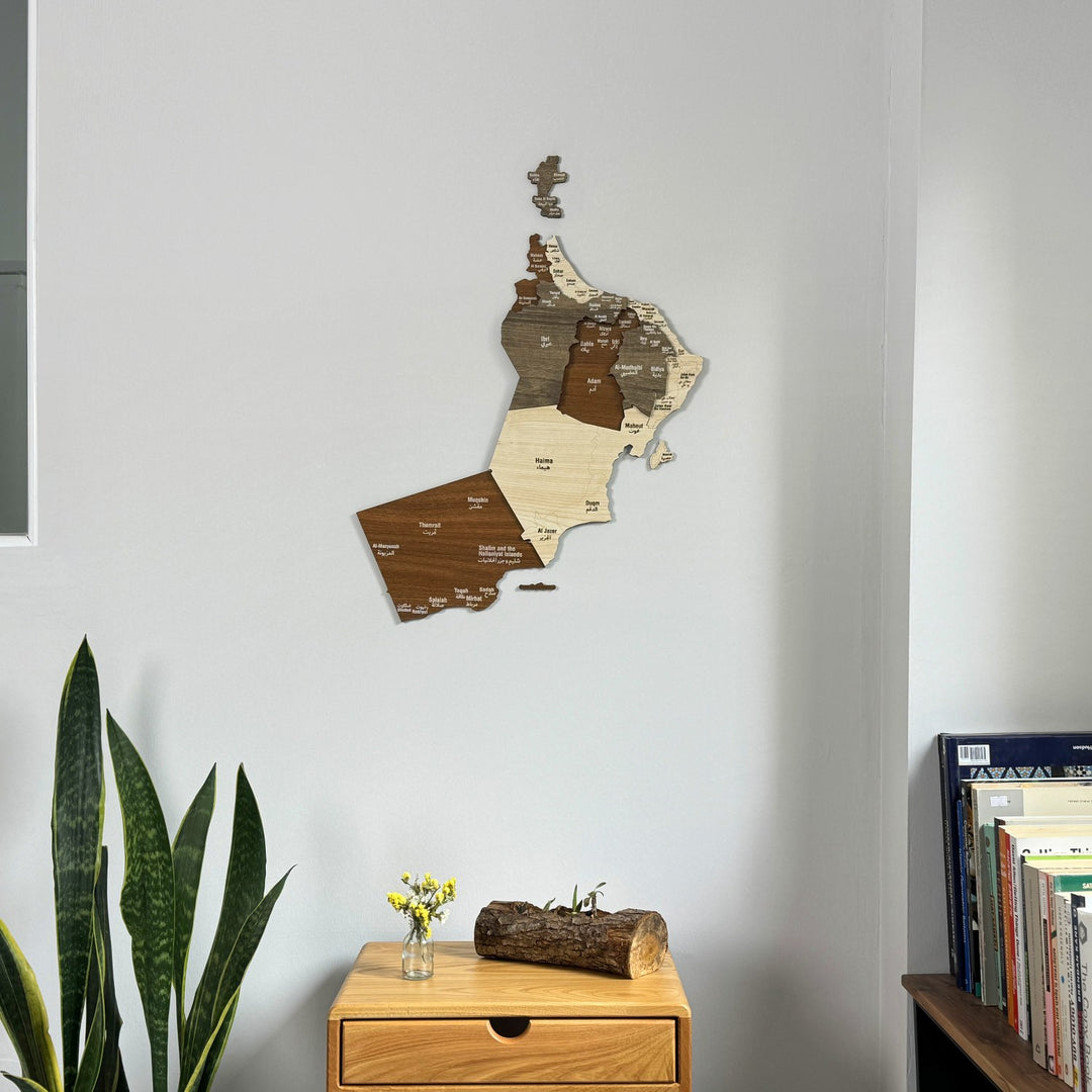 Oman wooden wall map in a corner room, closer view with a log centerpiece on a drawer table