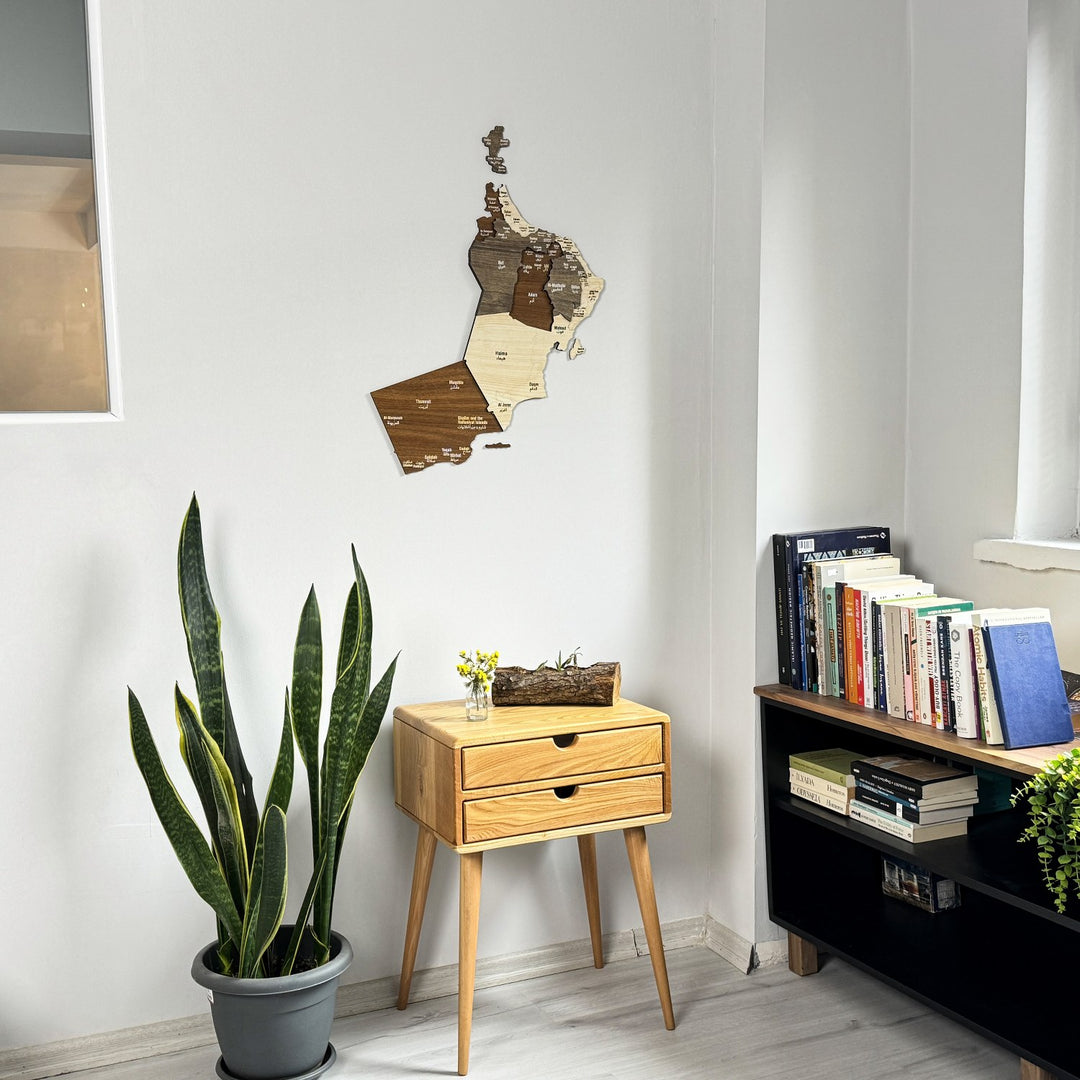 Oman wooden wall map hung high on a white wall in a reading corner, wide shot