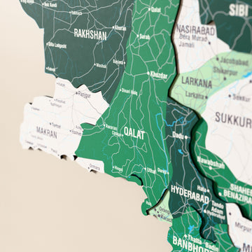Close-up of the Flag colored Pakistan wooden wall map with layered regions and printed names