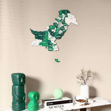 Flag colored Pakistan wooden wall map on a beige wall above a console with figurines