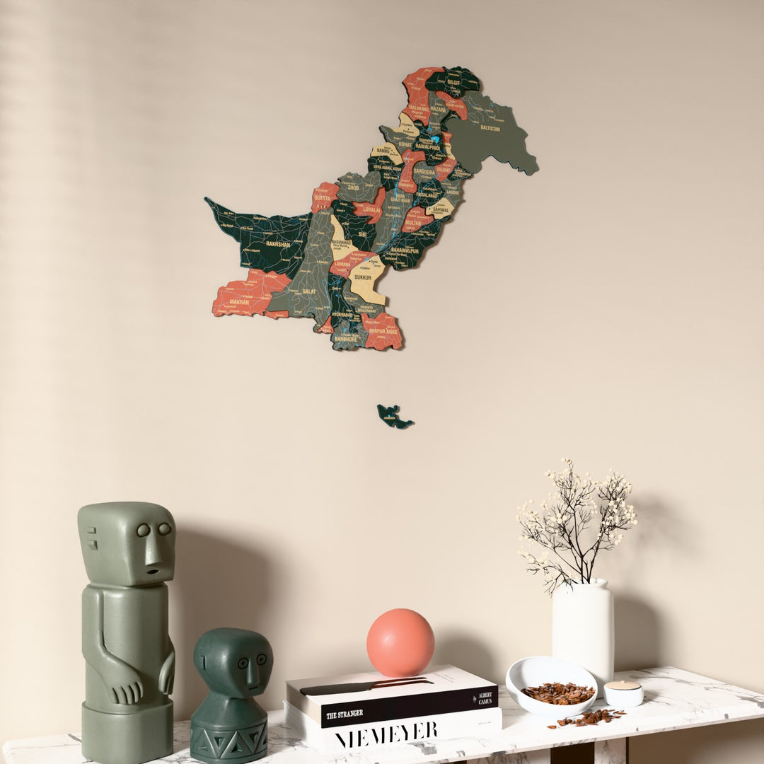 Sage Pakistan wooden wall map on a beige wall above a console with figurines
