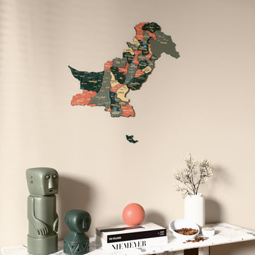 Sage Pakistan wooden wall map on a beige wall above a console with figurines