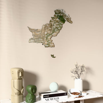 Satellite Pakistan wooden wall map on a beige wall above a console with figurines