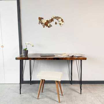 Wooden Panama map high on a white wall above a desk with a cream stool