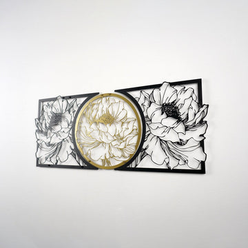 Black and gold floral metal wall decor on a light wall, right angle