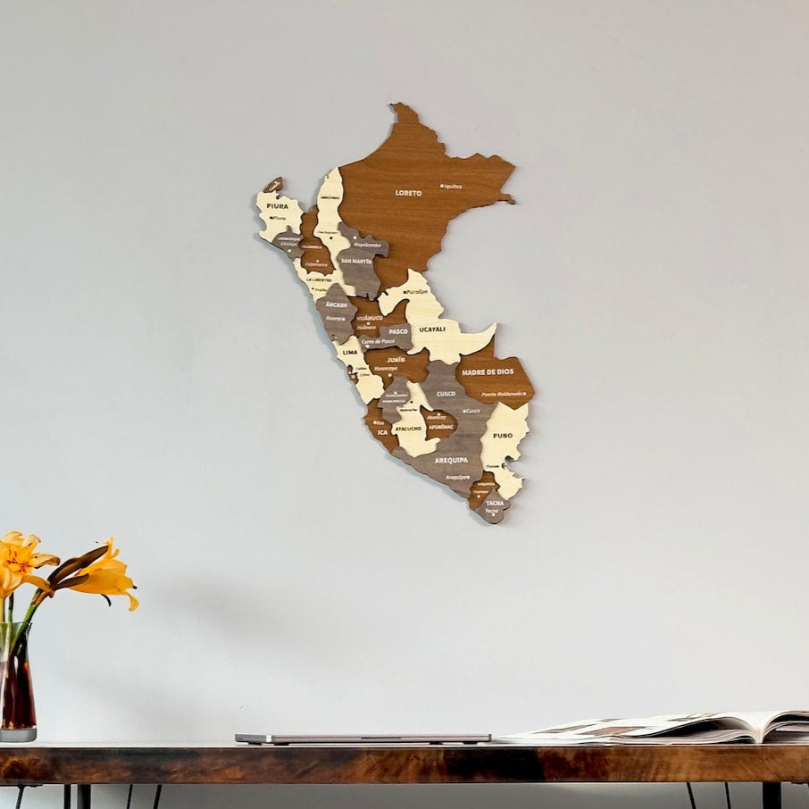 Peru wooden wall map in brown, beige and gray layers on a gray wall above a desk with yellow flowers