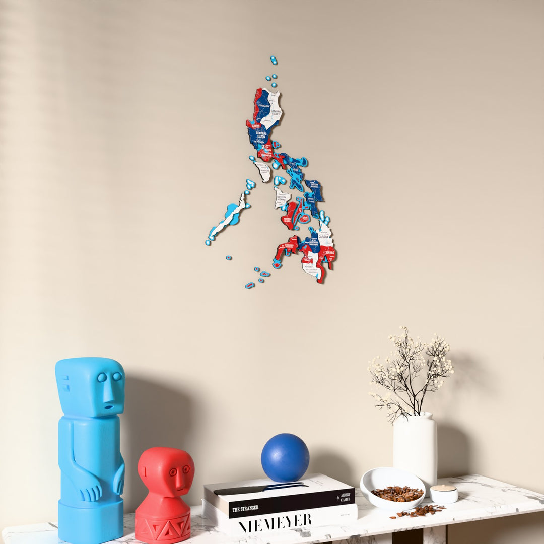 Flag colored Philippines wooden wall map on a beige wall above a console with figurines
