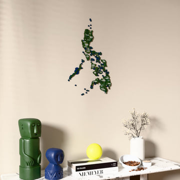 Satellite Philippines wooden wall map on a beige wall above a console with figurines