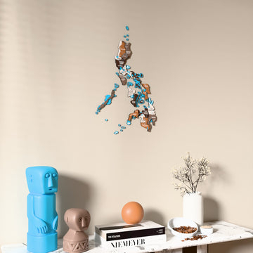 Soil Philippines wooden wall map on a beige wall above a console with figurines