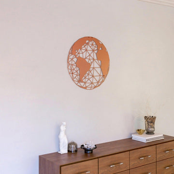 Copper polygon world map metal wall art above a dresser with a vase and figurine
