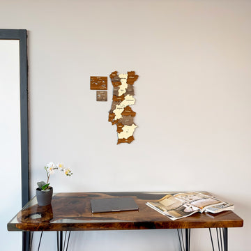 Portugal wooden wall map on a white wall above a resin desk, with an orchid and a gray frame at left