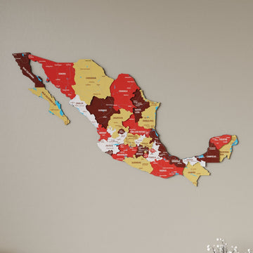 Terra Mexico wooden wall map in red, maroon and mustard states on a beige wall, angled view showing the layered pieces
