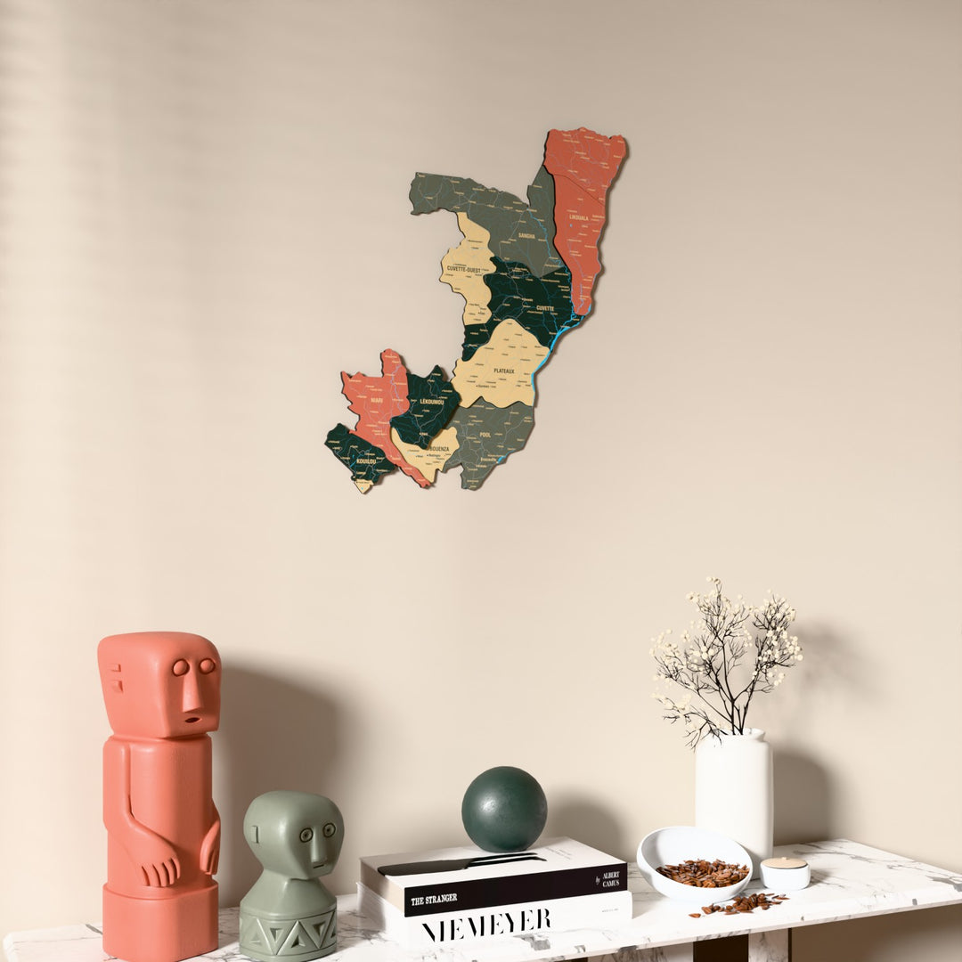Sage Republic of the Congo wooden wall map on a beige wall above a console with figurines