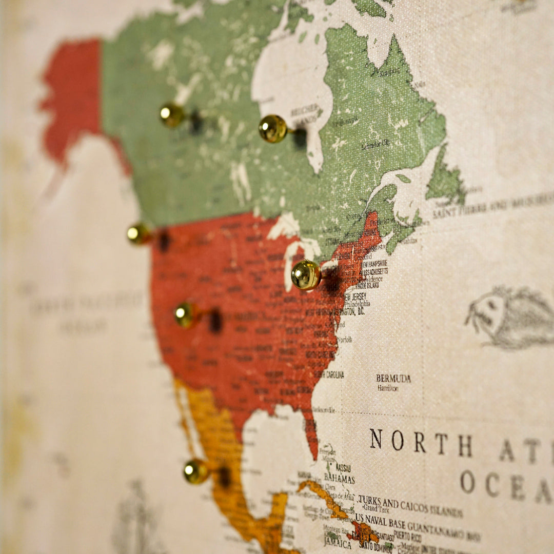 Gold map pins placed across the United States and Canada on the retro canvas world map