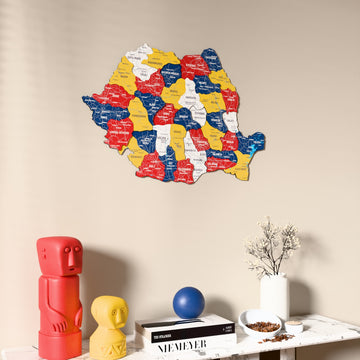 Flag colored Romania wooden wall map on a beige wall above a console with figurines