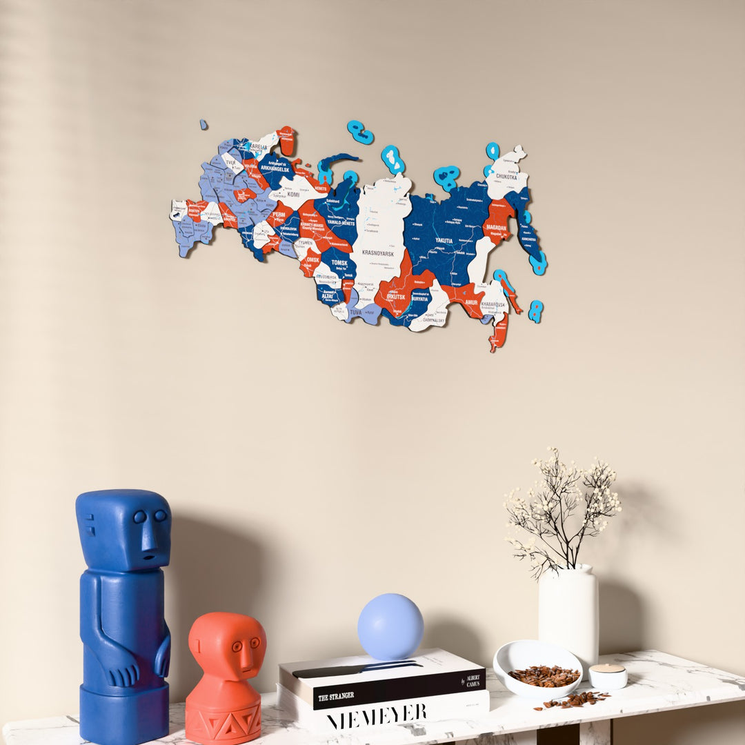 Flag colored Russia wooden wall map on a beige wall above a console with figurines