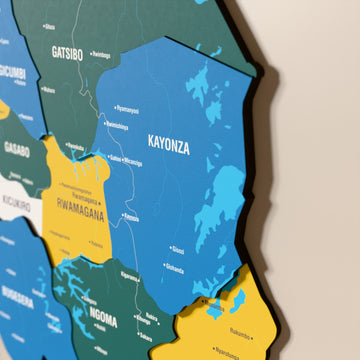Close-up of the Flag colored Rwanda wooden wall map with layered regions and printed names