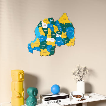 Flag colored Rwanda wooden wall map on a beige wall above a console with figurines