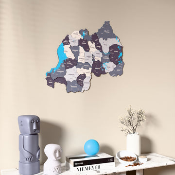 Nimbus Rwanda wooden wall map on a beige wall above a console with figurines