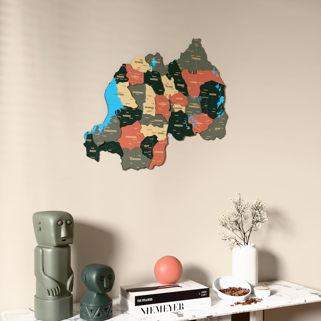 Sage Rwanda wooden wall map on a beige wall above a console with figurines