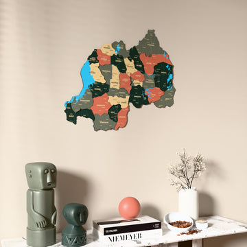 Sage Rwanda wooden wall map on a beige wall above a console with figurines