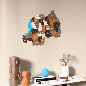 Soil Rwanda wooden wall map on a beige wall above a console with figurines