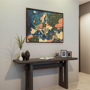 Wooden Europe map with rivers in Sage, above a dark console table with an open book