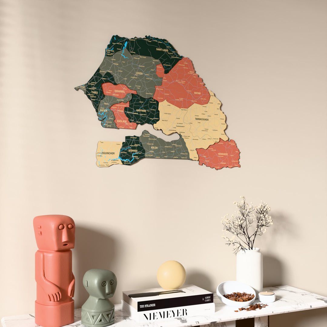 Sage Senegal wooden wall map on a beige wall above a console with figurines