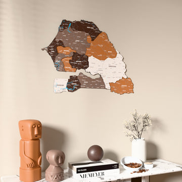 Soil Senegal wooden wall map on a beige wall above a console with figurines