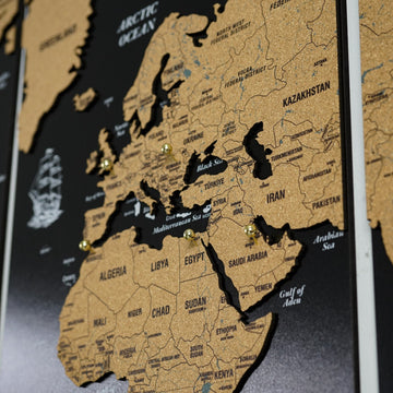 Close-up of Europe, Africa and the Middle East on the black cork world map with brass push pins