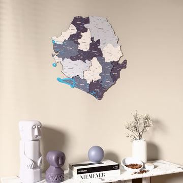 Nimbus Sierra Leone wooden wall map on a beige wall above a console with figurines
