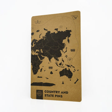 Kraft cover of the 276 silicone map pin set, closed, with a world map and Country and State Pins on it