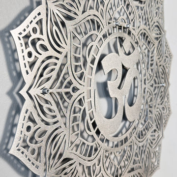 Side-angle close-up of the silver OM mandala metal wall art showing the raised OM symbol and mounting points