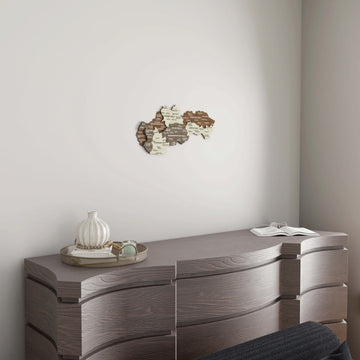 Small Slovakia wooden wall map above a gray wavy-front dresser with a white vase