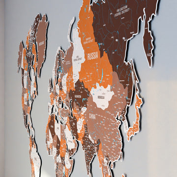 Side-angle close-up of Russia, Mongolia and China on the Soil metal world map in orange and brown