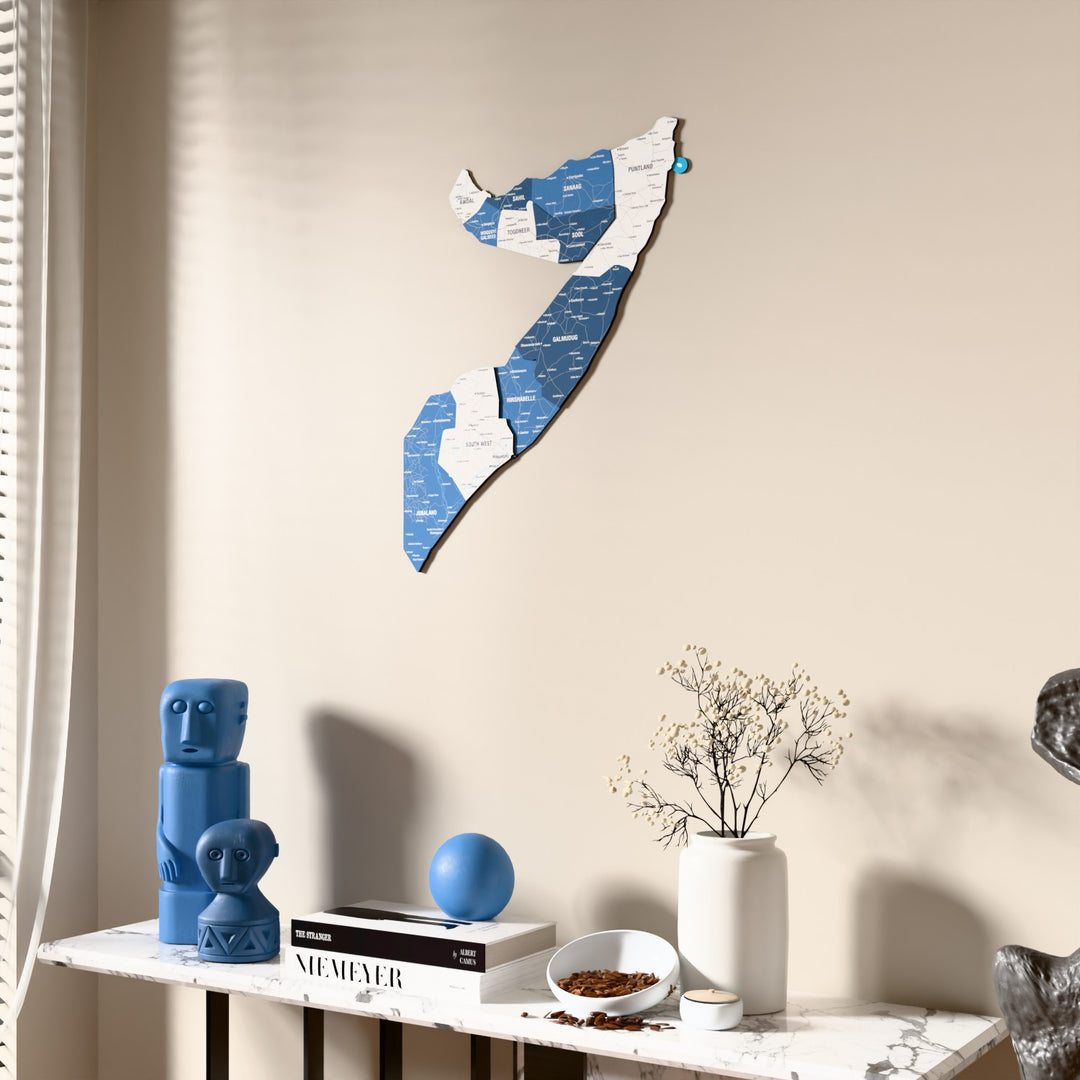 Flag colored Somalia wooden wall map beside a sheer curtain, angled view