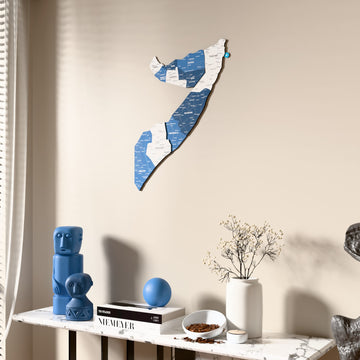 Flag colored Somalia wooden wall map beside a sheer curtain, angled view