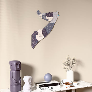Nimbus Somalia wooden wall map on a beige wall above a console with figurines