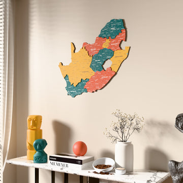 Flag colored South Africa wooden wall map beside a sheer curtain, angled view