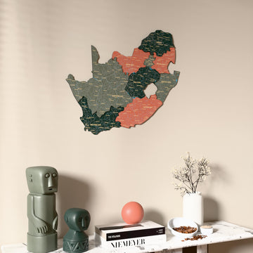 Sage South Africa wooden wall map on a beige wall above a console with figurines