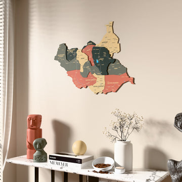 Sage South Sudan wooden wall map beside a sheer curtain, angled view