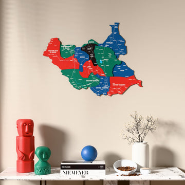 Flag colored South Sudan wooden wall map above a marble console, front view