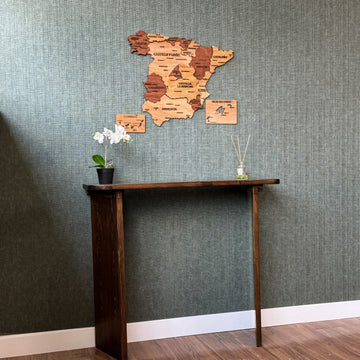 Wooden Spain map above a tall console table, wide view with white baseboard