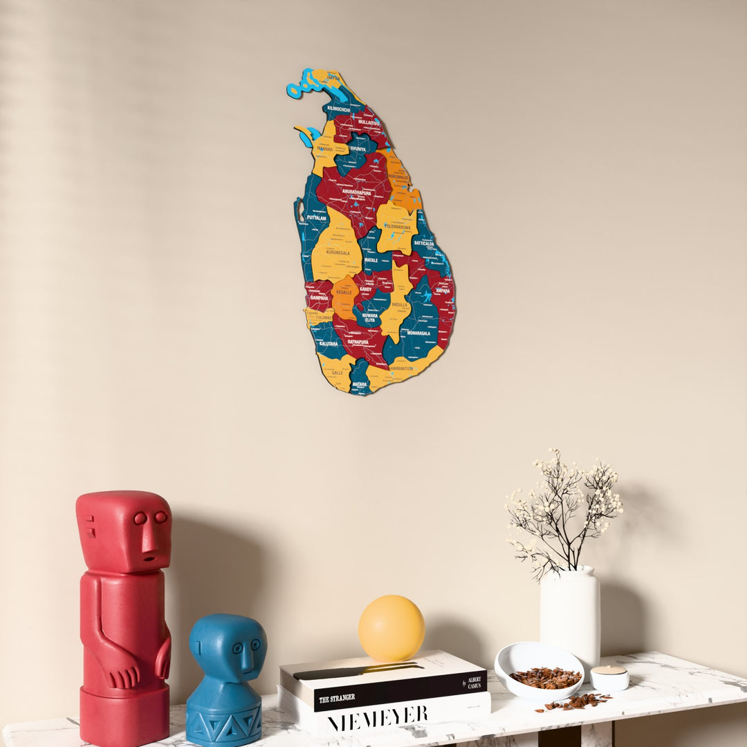 Flag colored Sri Lanka wooden wall map on a beige wall above a console with figurines