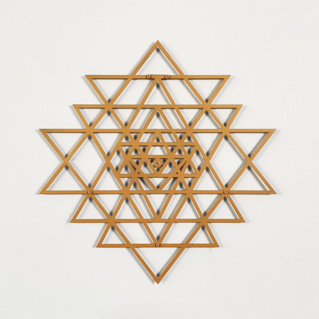 Wooden geometric wall art with a copper star-like pattern on a light gray background