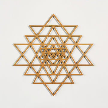 Wooden geometric wall art with a copper star-like pattern on a light gray background