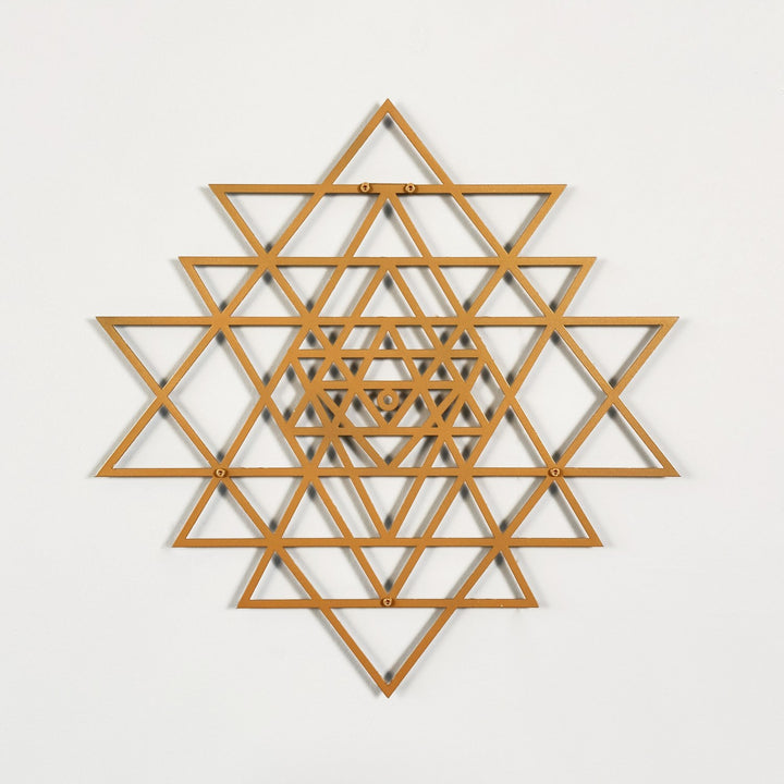 Wooden geometric wall art with a copper star-like pattern on a light gray background